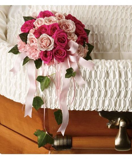 Mixed pink roses and ribbon for casket adornment.